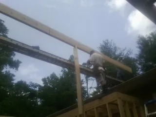 Carpenter setting a ridge beam over a new addition frame — Ice Dam Removal by Roofing Brothers in De Pere