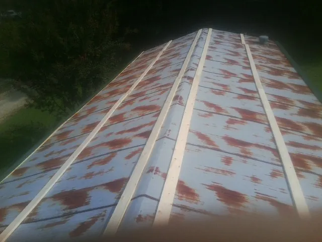 Rusted metal roof panels with new wood purlins before replacement — Storm Damage Roof Repair in De Pere by Roofing Brothers