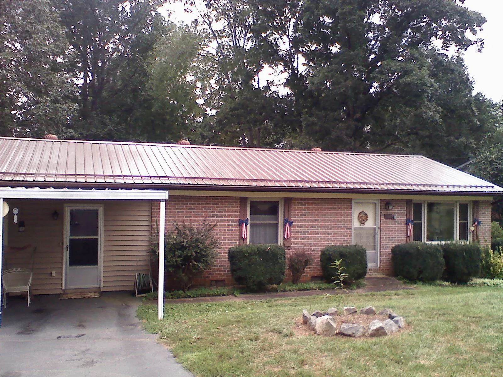 Bronze metal roof and carport on a brick ranch home — Roof Repair work by our crew in De Pere